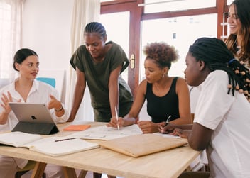 group of women at a desk discussing nonprofit capacity building