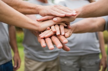 Volunteers with hands together