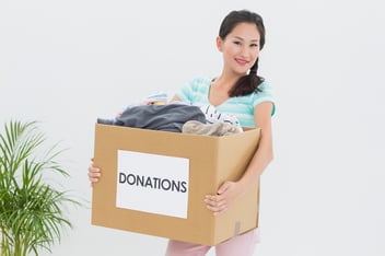 Volunteer holding a box of donations as a result of nonprofit improved donor relationship.