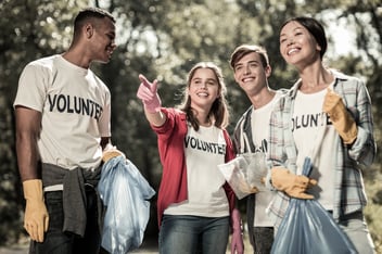 Group of smiling volunteers showing different types of volunteering