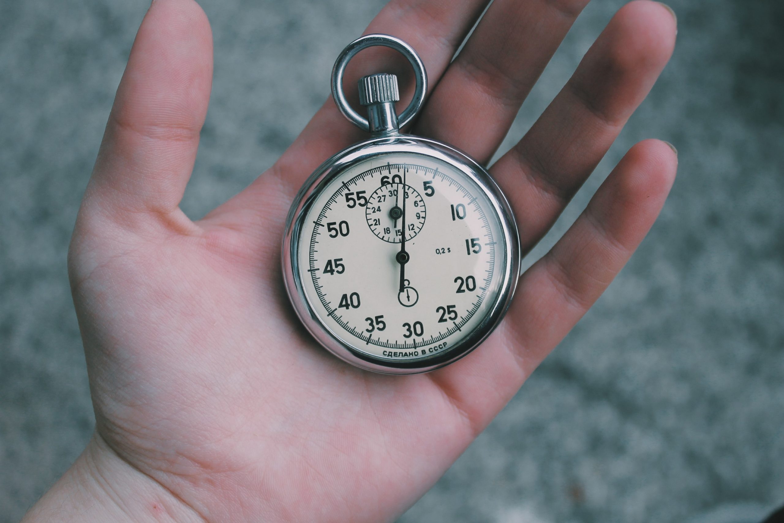 Volunteer hours log of hand holding stopwatch to record volunteer time in a volunteer tracking sheet
