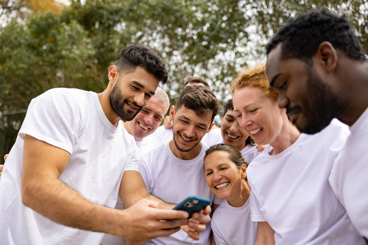 Group of volunteers looking at social media posts during their outdoor activities.